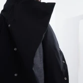 Длинное зимнее пальто на кнопках черного цвета, крупный план