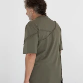 Асимметричная зеленая футболка на модели, задний боковой вид