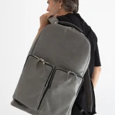 Большой кожаный рюкзак серый на плече мужчины