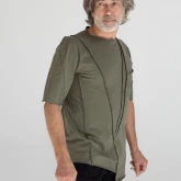 Асимметричная зеленая футболка на модели, вид сбоку спереди